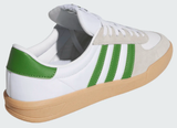 White sneaker with green stripes and tan sole on a light gray background